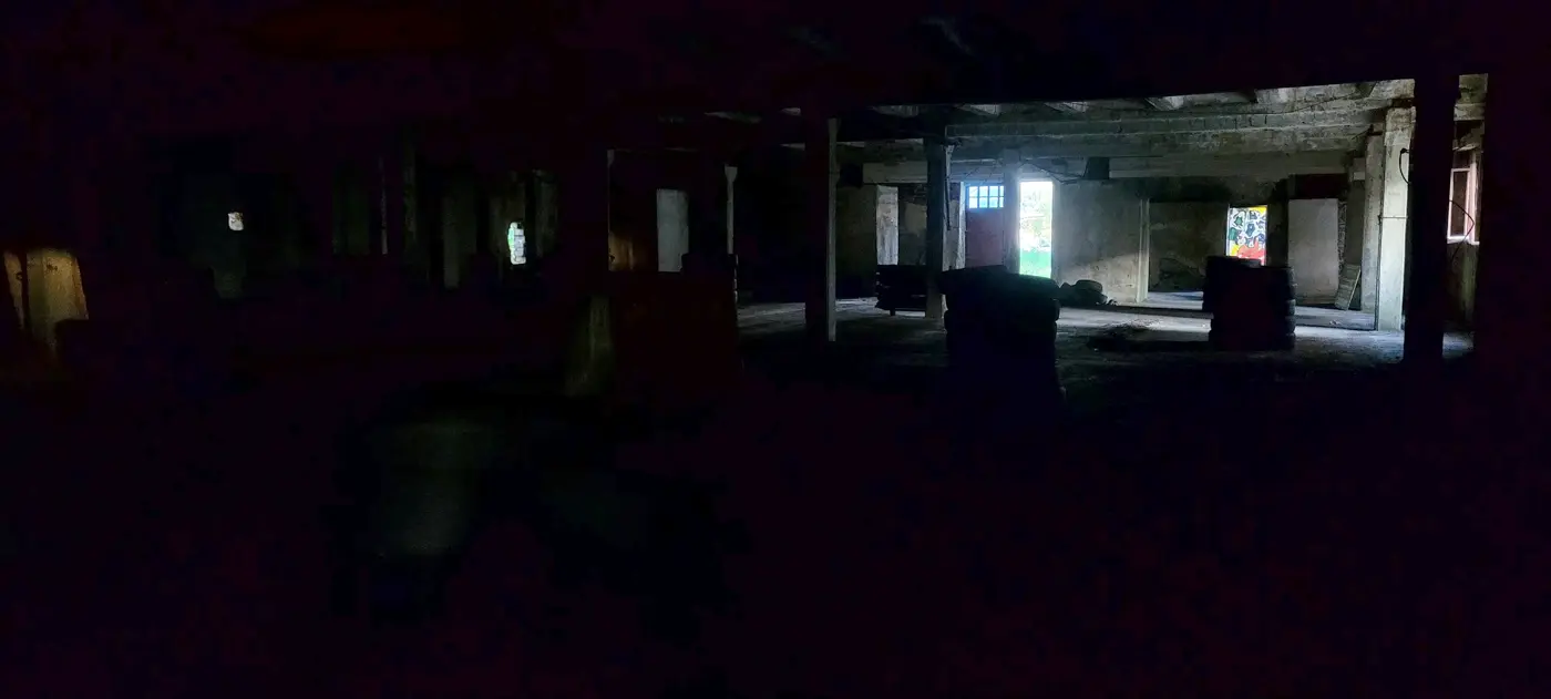Teren întunecat de la parterul arenei FOKS, cu stâlpi, cauciucuri și lumină care intră pe la uși și ferestre